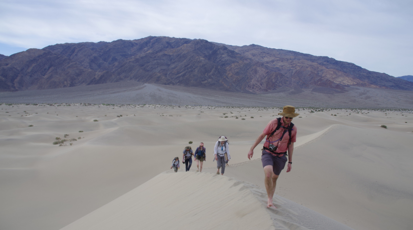 Researchers walk on sand dune in Death Valley